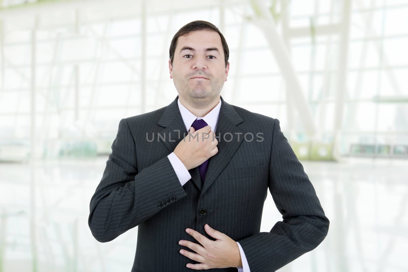 young business man adjusting his tie, isolated on white