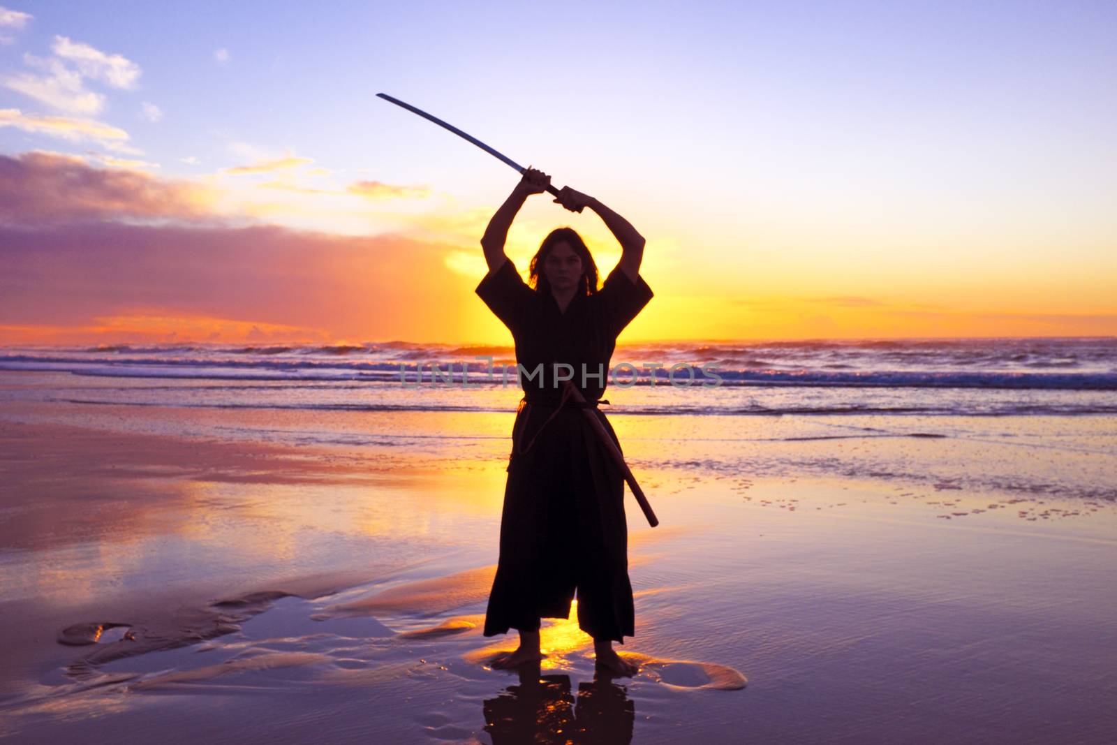 Young samurai women with Japanese sword(Katana) at sunset on the by devy