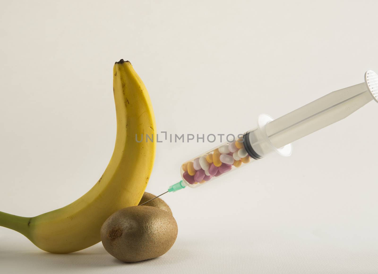 Male impotence metaphor: banana,kiwi and syringe with pills