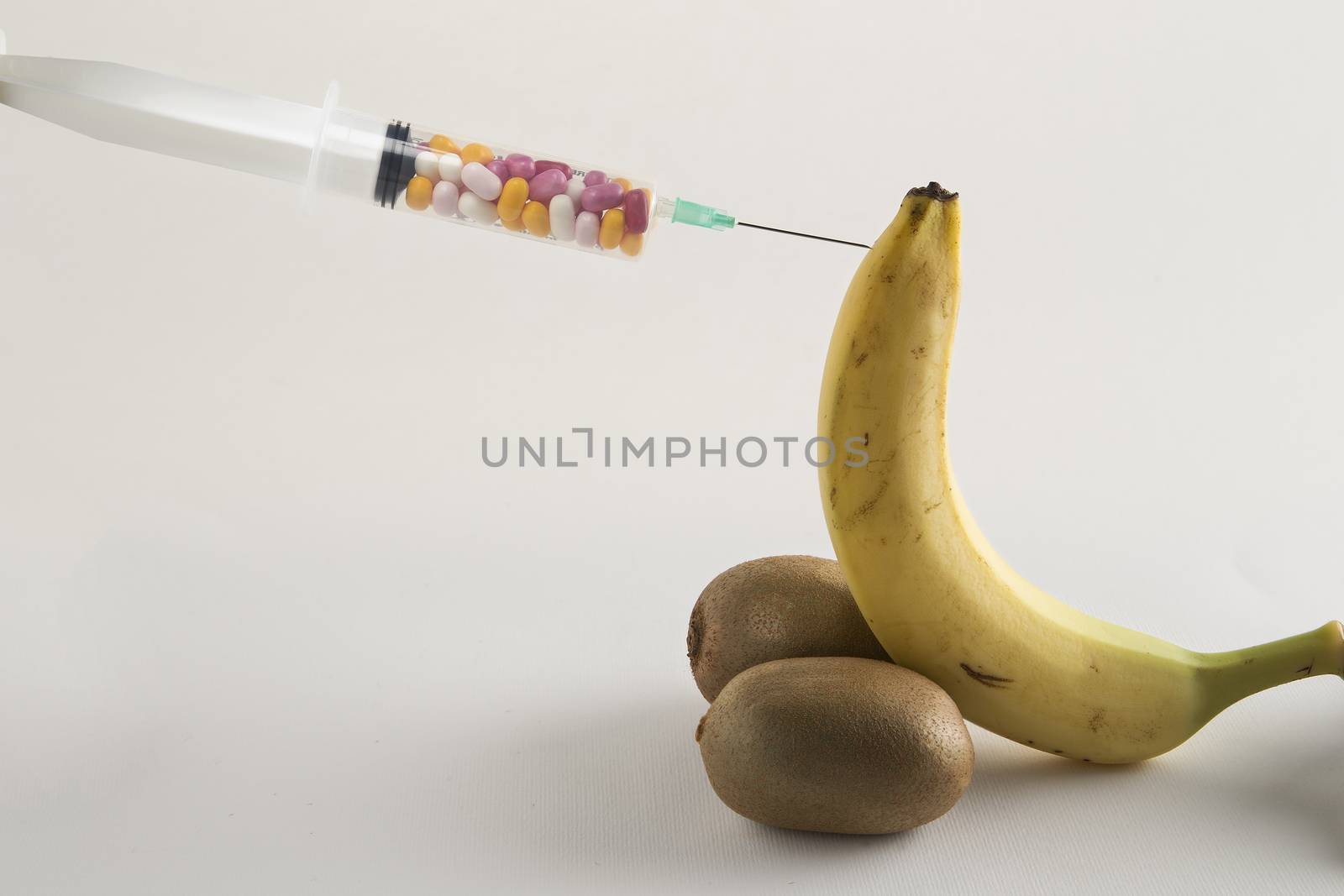 Banana, kiwi and syringe of pills