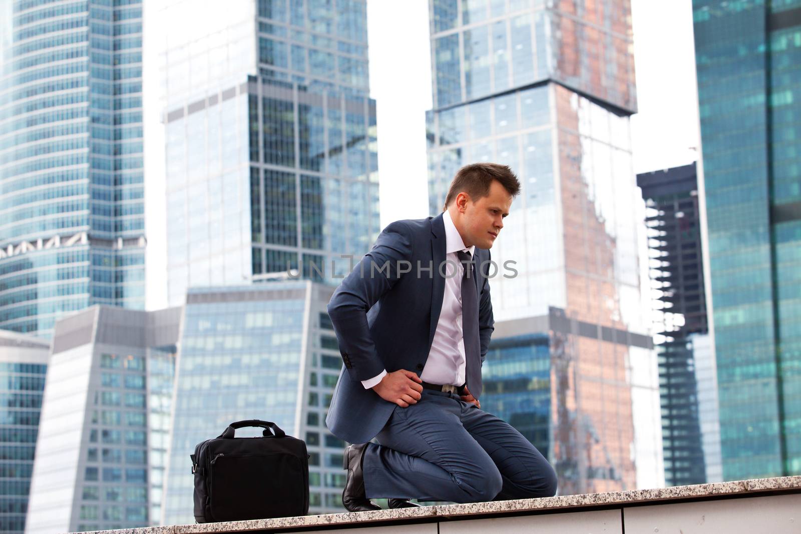 successful businessman meditation on the background of office buildings
