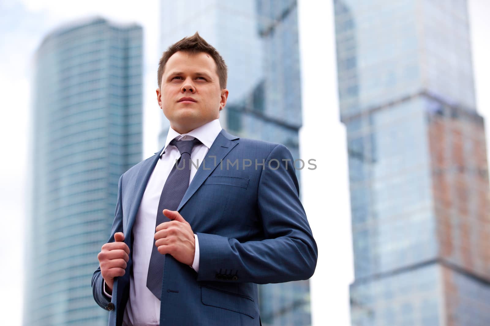 Businessman near office towers by Astroid
