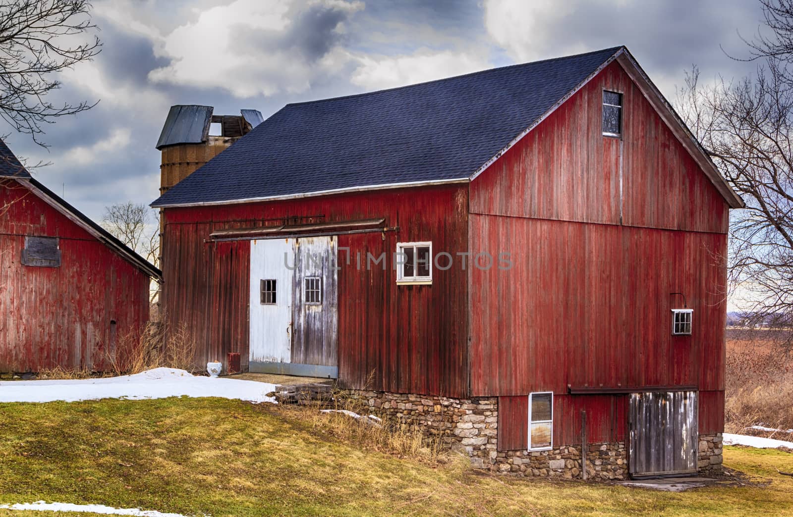 Large red bank barn. New Roof. Crisp colors and overcast sky. 