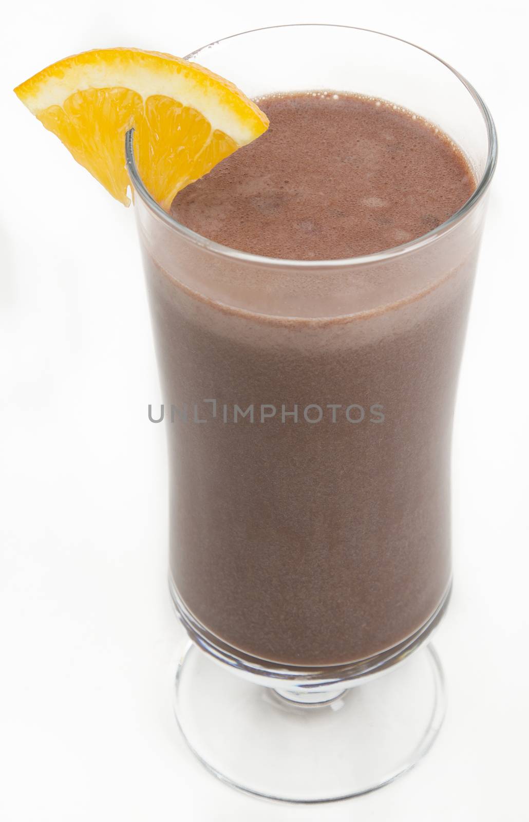 Chocolate milkshake with a slice of orange on the side against a white background