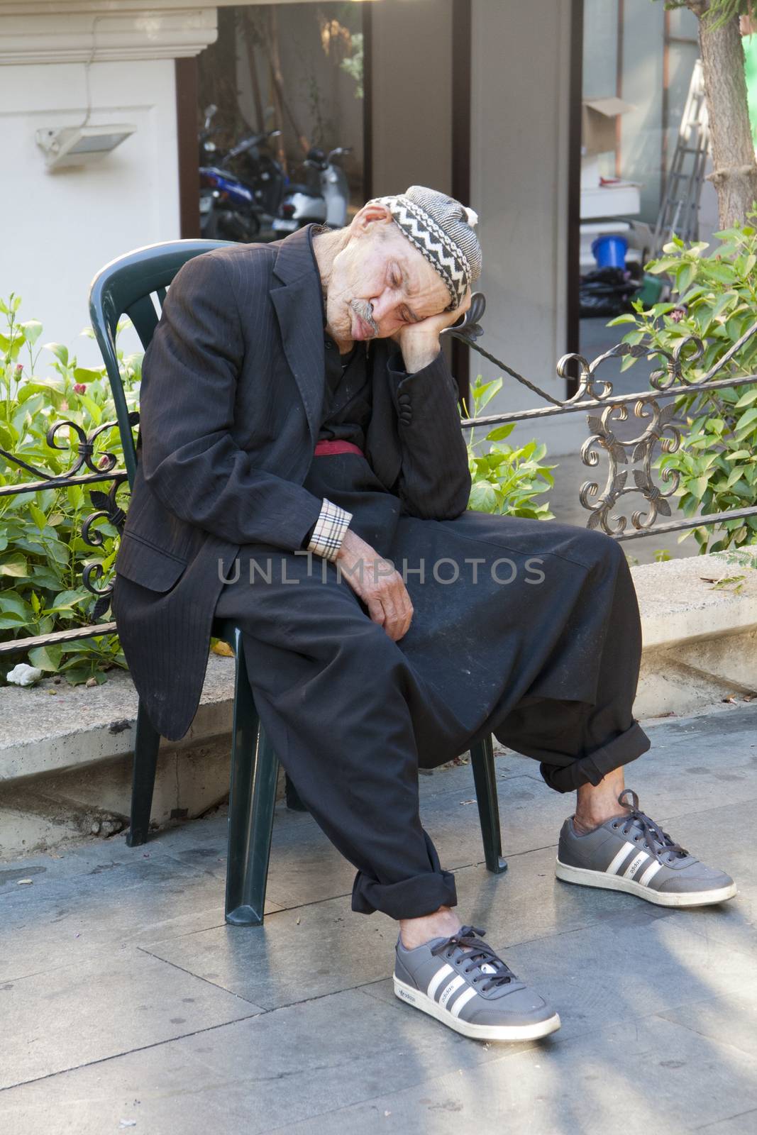 Alanya, Turkey-September 24th 2011: An old man takes a nap on a hot afternoon. It is common in Turkey to see old men taking a nap in the afternoons.