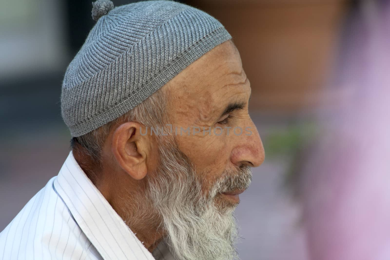 Alanya, Turkey-September 20th 2011: Man wearing a traditional Turkish skull cap. The cap is made of wool or cotton and has a pom pom on top.