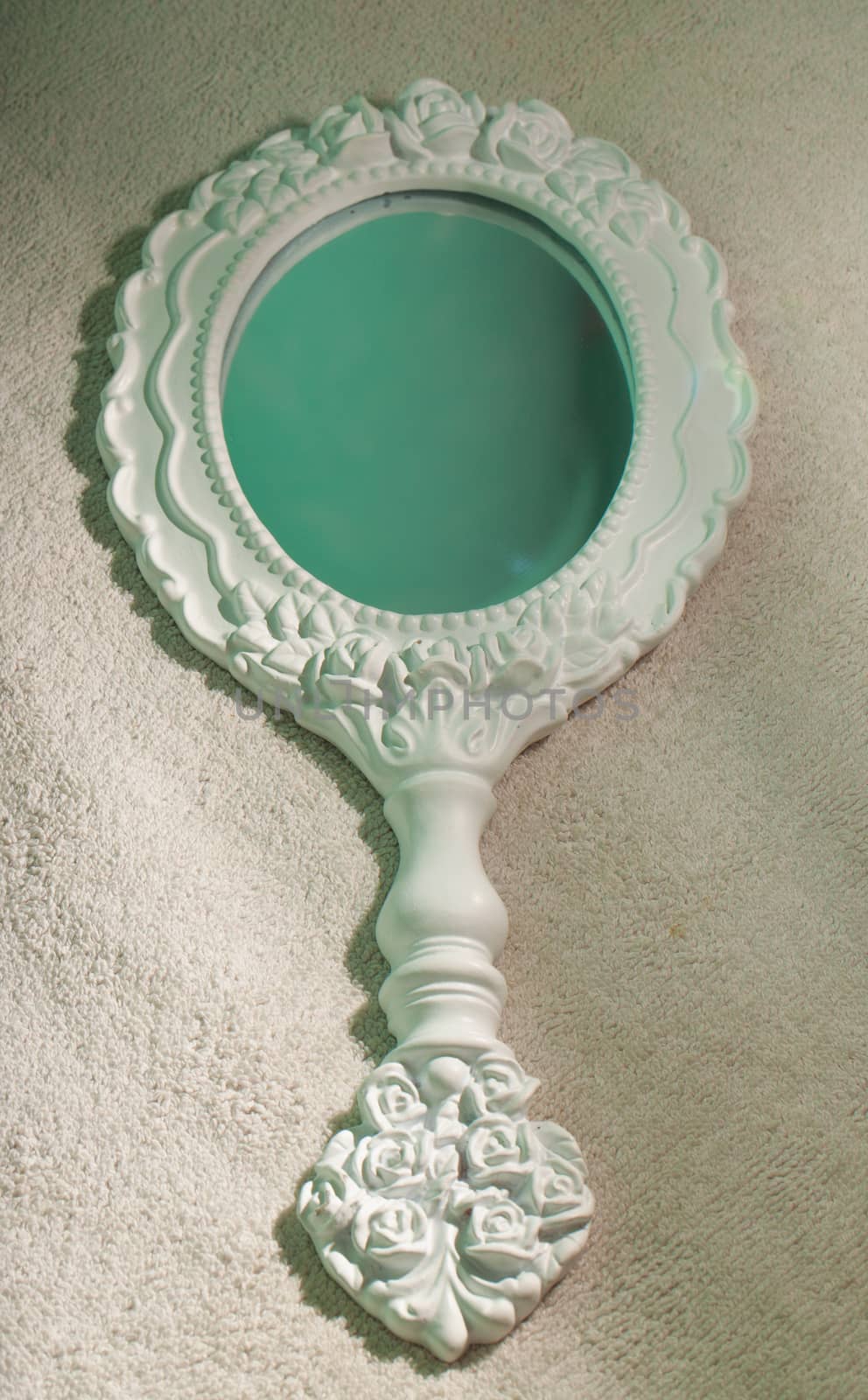 Small decorated white mirror over white background