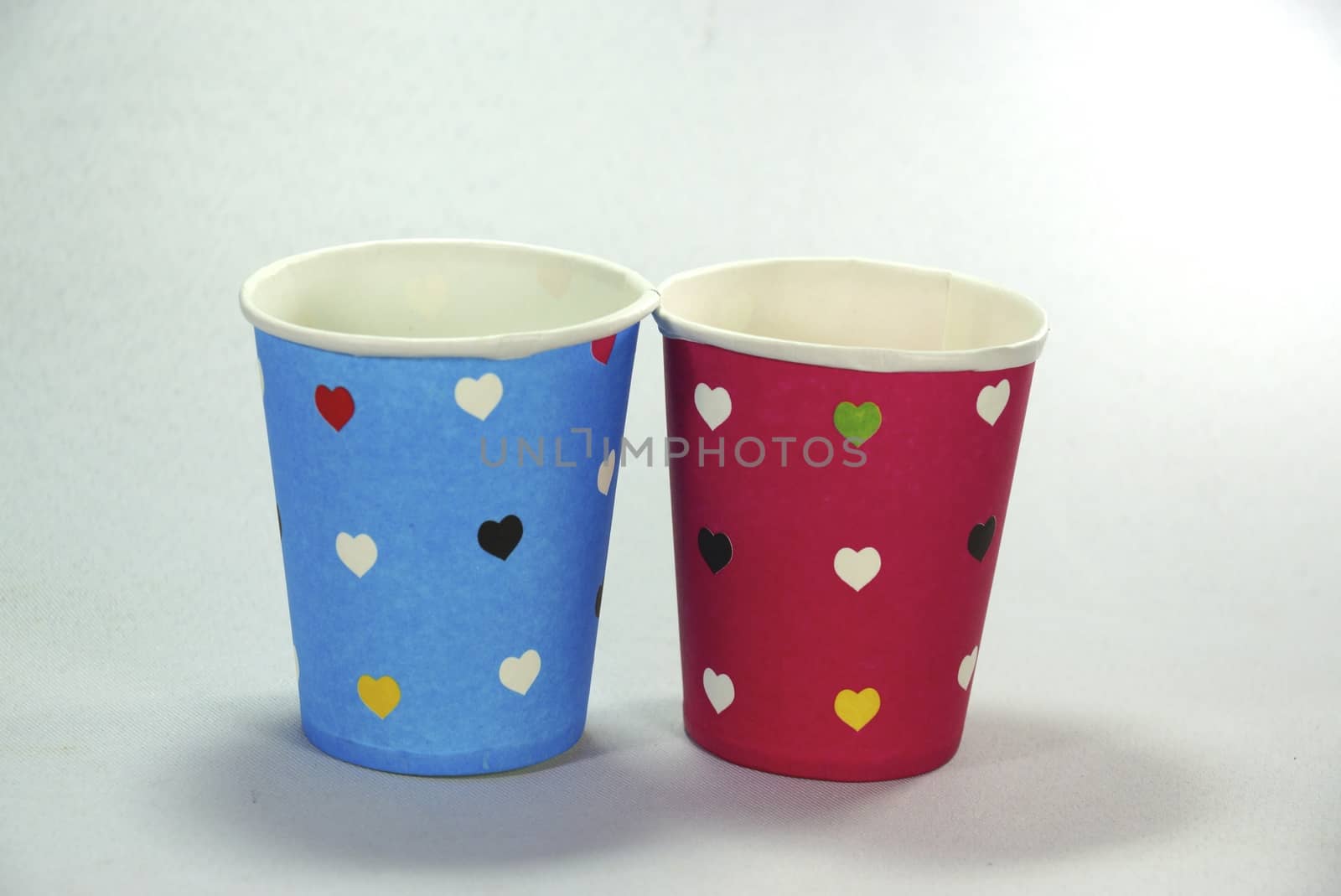 two colourful paper cups on white scene,shallow focus