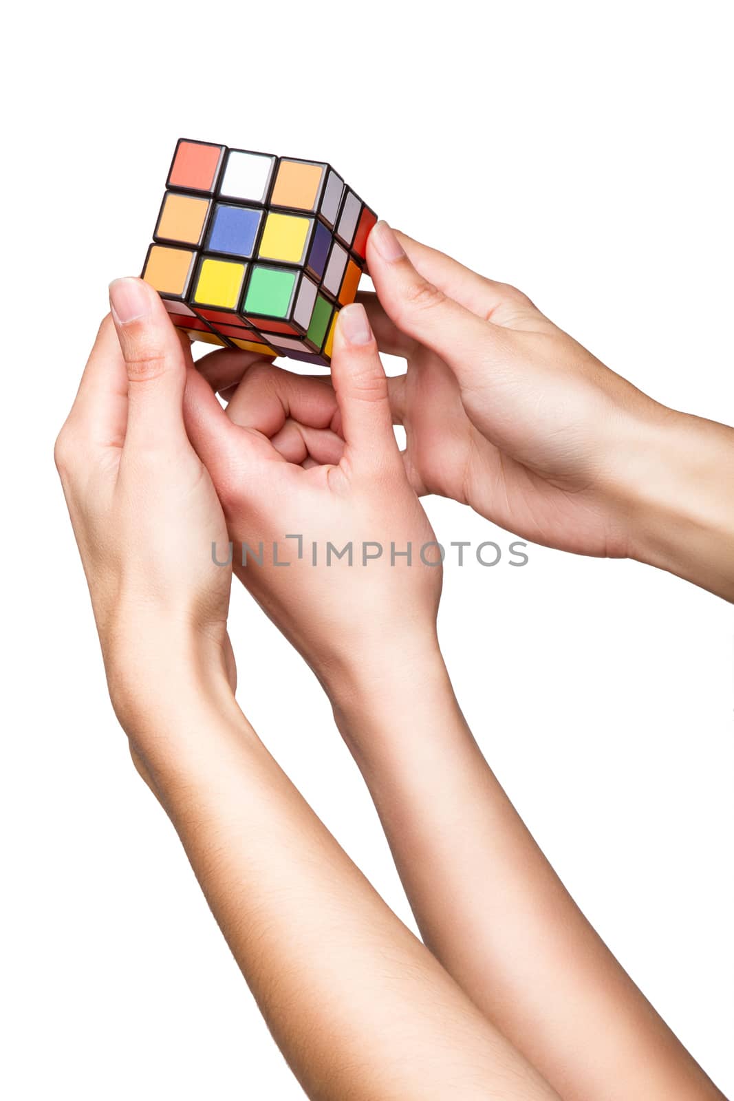 Hands holding color cube on white background