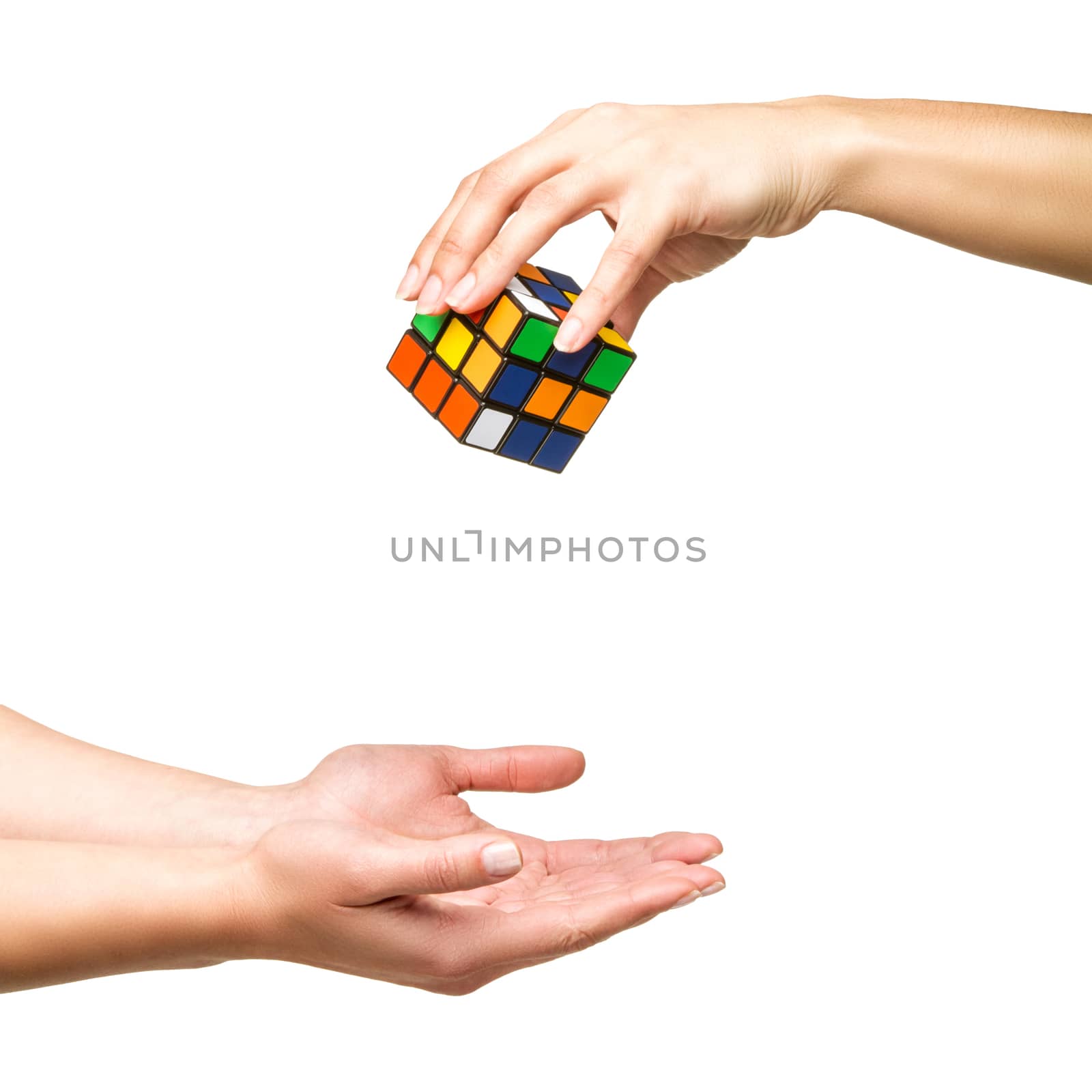 Hand dropping color cube on white background