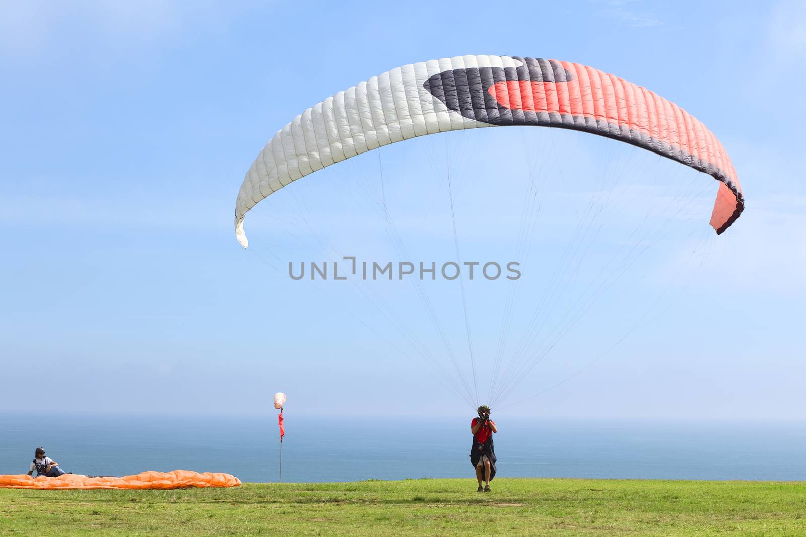 LIMA, PERU - FEBRUARY 20, 2012: Unidentified person with a paraglider on the coast of Miraflores on February 20, 2012 in Lima, Peru. Paragliding is a popular sport on the coast of Miraflores, where winds are usually good and in good weather a big part of the coast of Lima can be seen. 