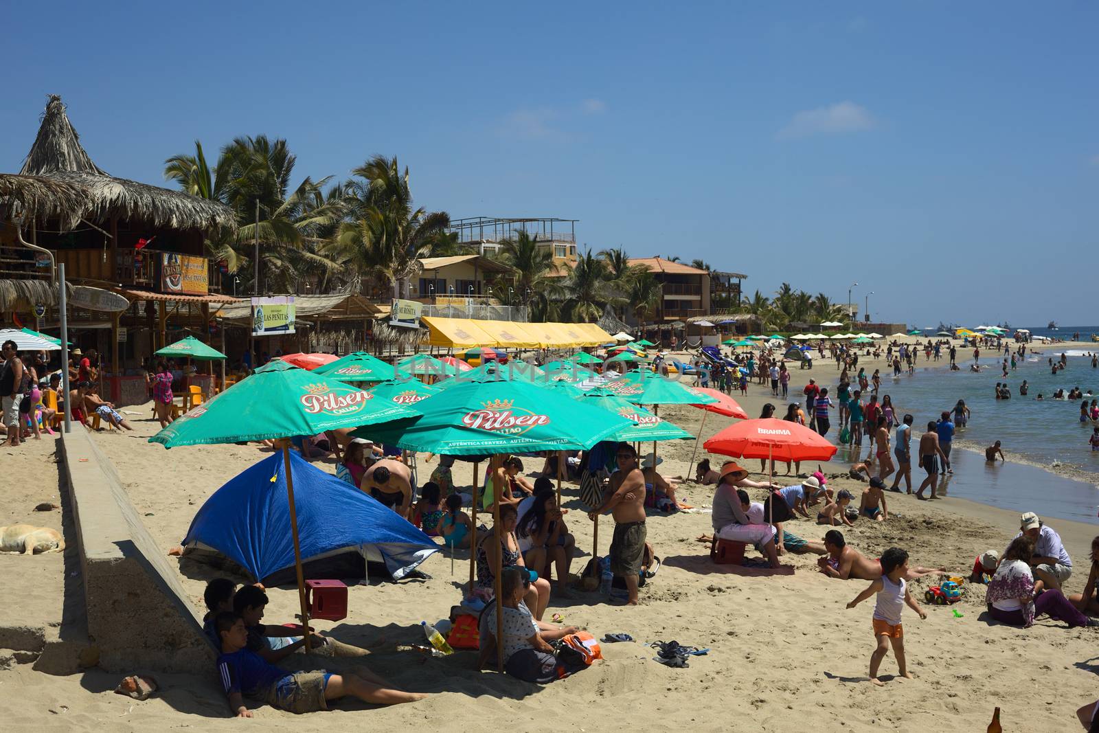 MANCORA, PERU - AUGUST 17, 2013: Unidentified people on the beach on August 17, 2013 in Mancora, Peru. Mancora is a small beach and party town in Northern Peru, which is popular with both national and international tourists. 
