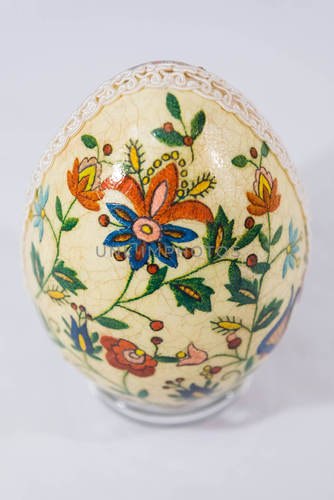 Easter egg decorated with flowers made by decoupage technique on light background