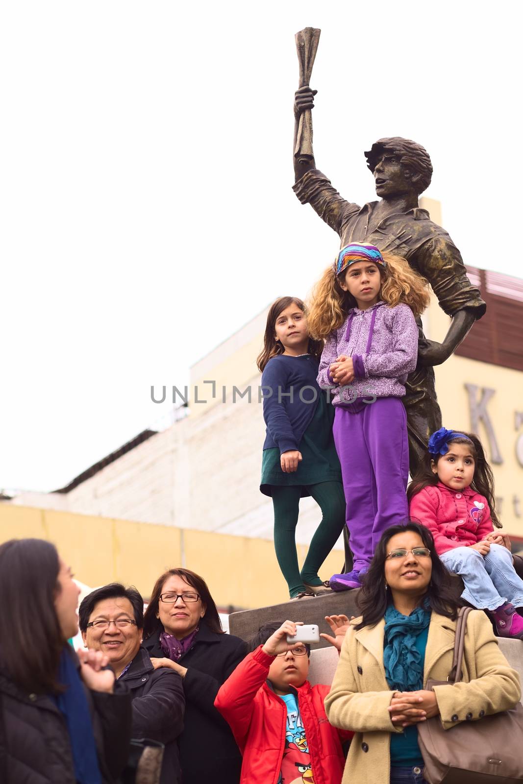 LIMA, PERU - JULY 21, 2013: Unidentified people watching the Parade of Wong from the statue of the "Lector" on Avenue Ricardo Palma at the Ovalo Miraflores on July 21, 2013 in Lima, Peru. The Parade (Gran Corso) is a traditional parade to celebrate the Peruvian national holiday which is on July 28-29. 