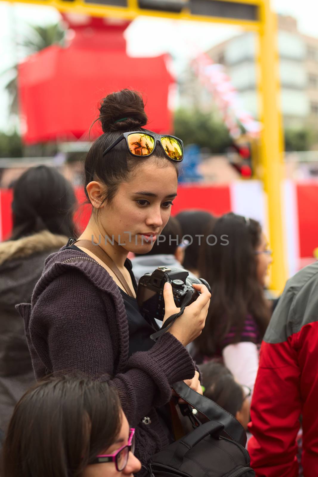 LIMA, PERU - JULY 21, 2013: Unidentified young woman with camera on the Wong Parade in Miraflores on July 21, 2013 in Lima, Peru. The Parade (Gran Corso de Wong) is a traditional parade to celebrate the Peruvian national holiday which is on July 28-29.