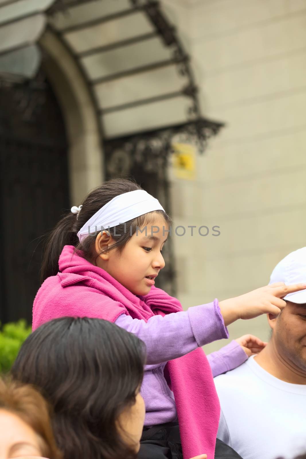 LIMA, PERU - JULY 21, 2013: Unidentified young girl pointing on the Wong Parade in Miraflores on July 21, 2013 in Lima, Peru. The Parade (Gran Corso de Wong) is a traditional parade to celebrate the Peruvian national holiday which is on July 28-29. 