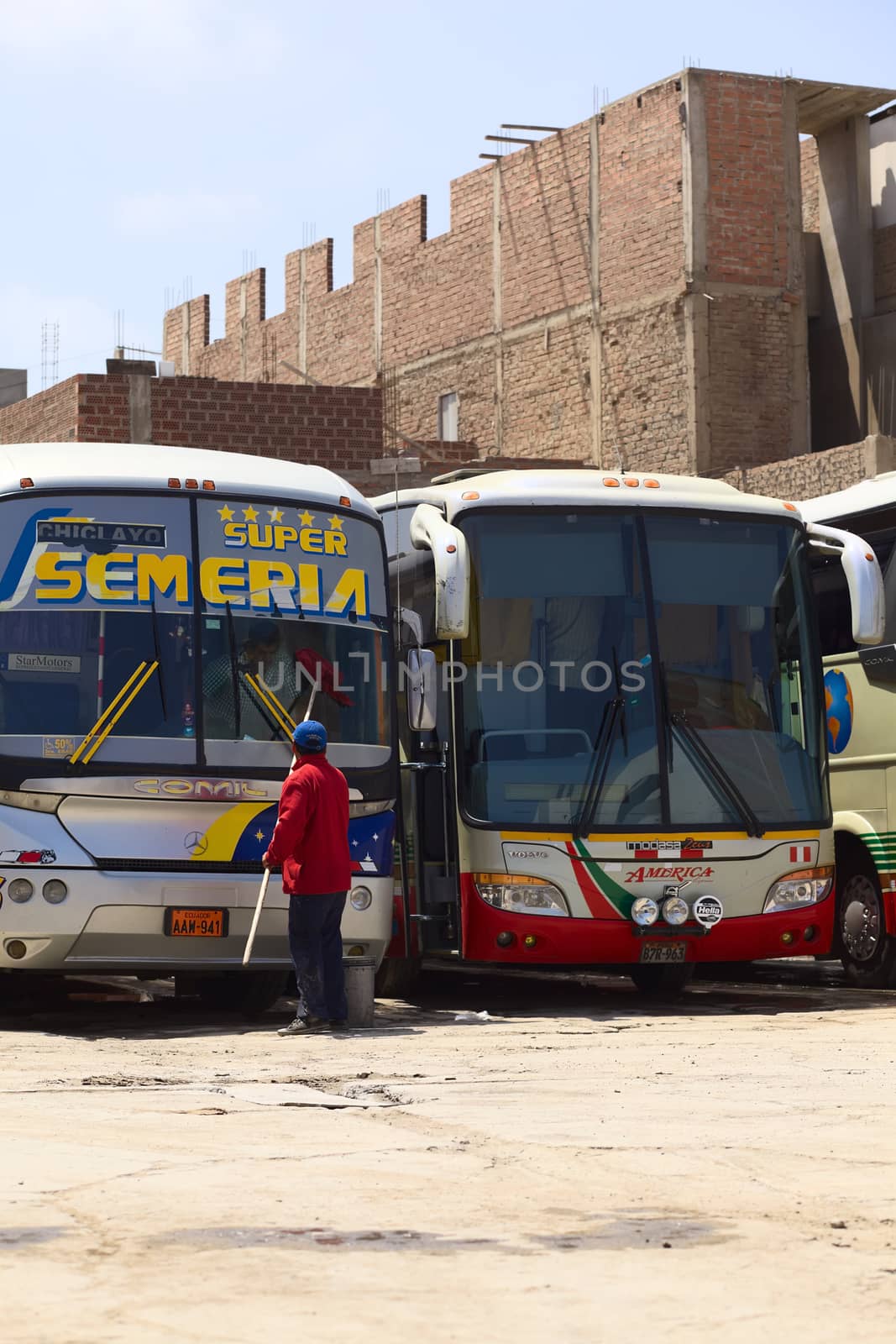 Person Cleaning the Window of a Long-Distance Bus in Chiclayo, Peru by sven