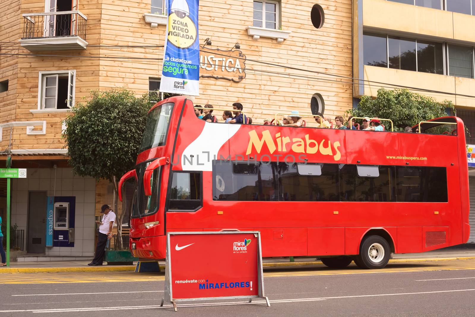 LIMA, PERU - APRIL 1, 2012: Unidentified people on Mirabus sightseeing bus in front of the restaurant Rustica on Av. Diagonal in Miraflores on April 1, 2012 in Lima, Peru. Miraflores is the tourist district of Lima, with a lot of infrastructure for tourism.