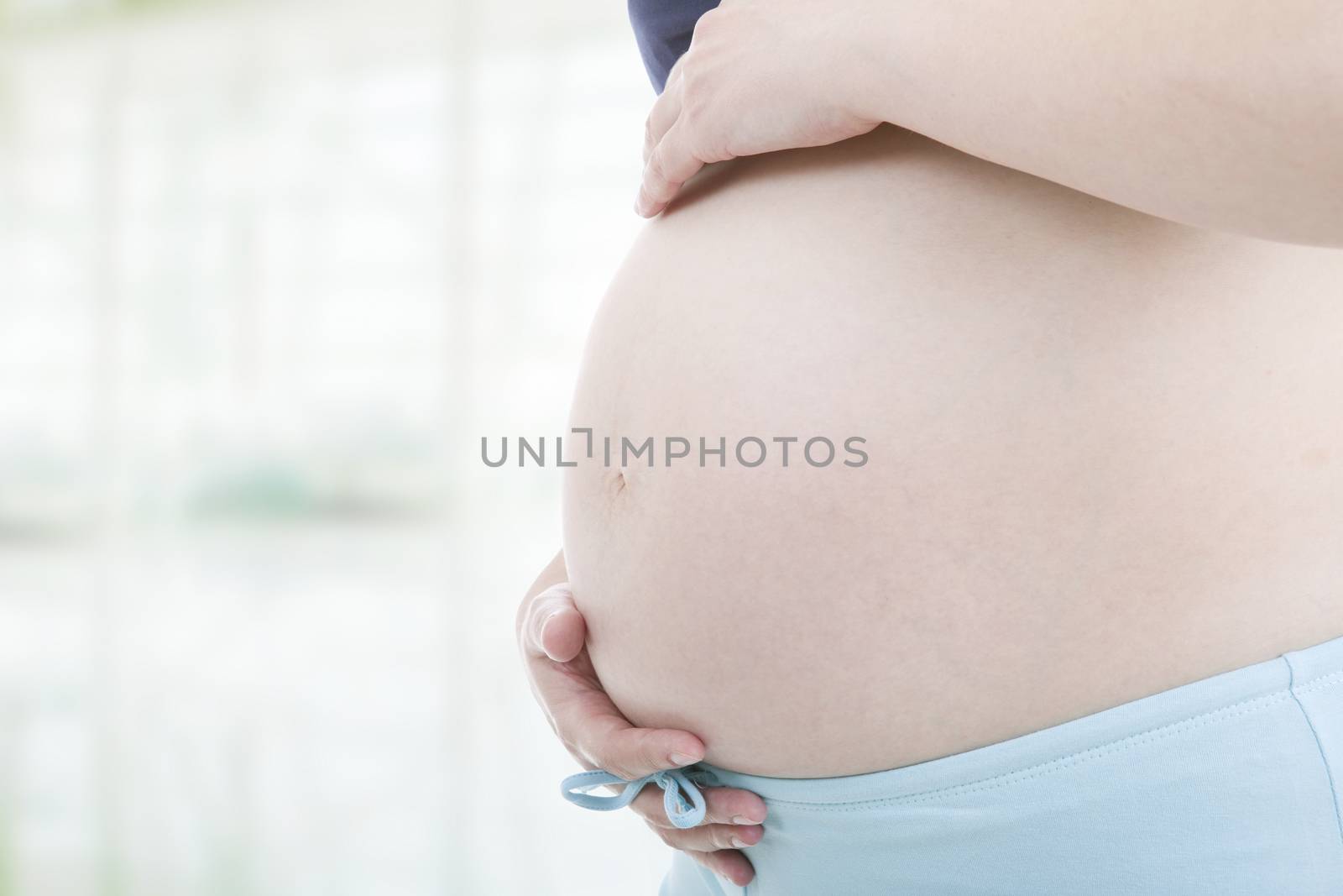 Closeup of pregnant woman at white background