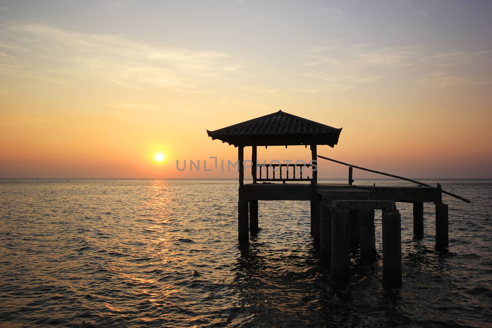  Silhouette of old pavilion in the sea at sunset