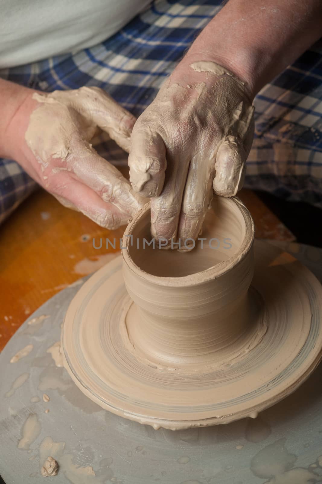 Hands of a potter, creating an earthen jar on the circle