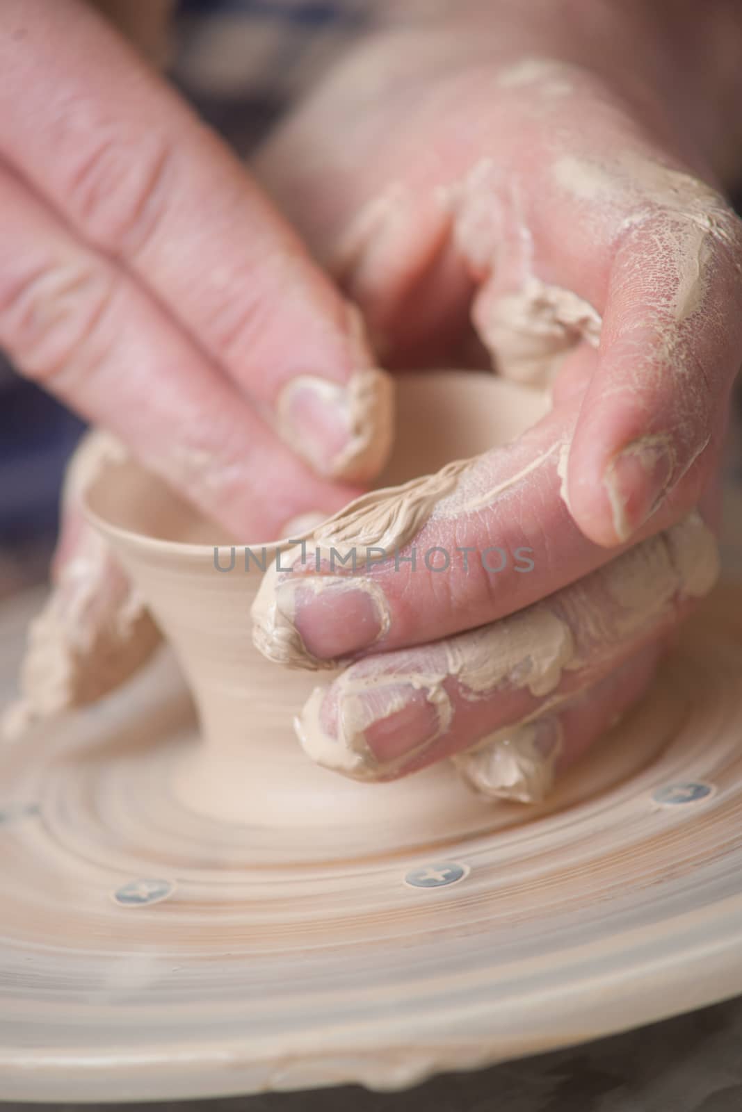 Hands of a potter, creating an earthen jar on the circle