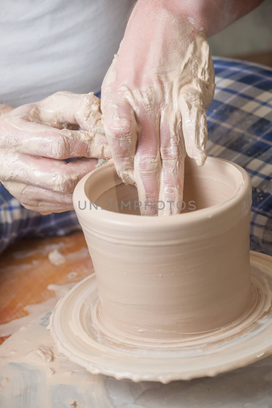 Hands of a potter, creating an earthen jar on the circle