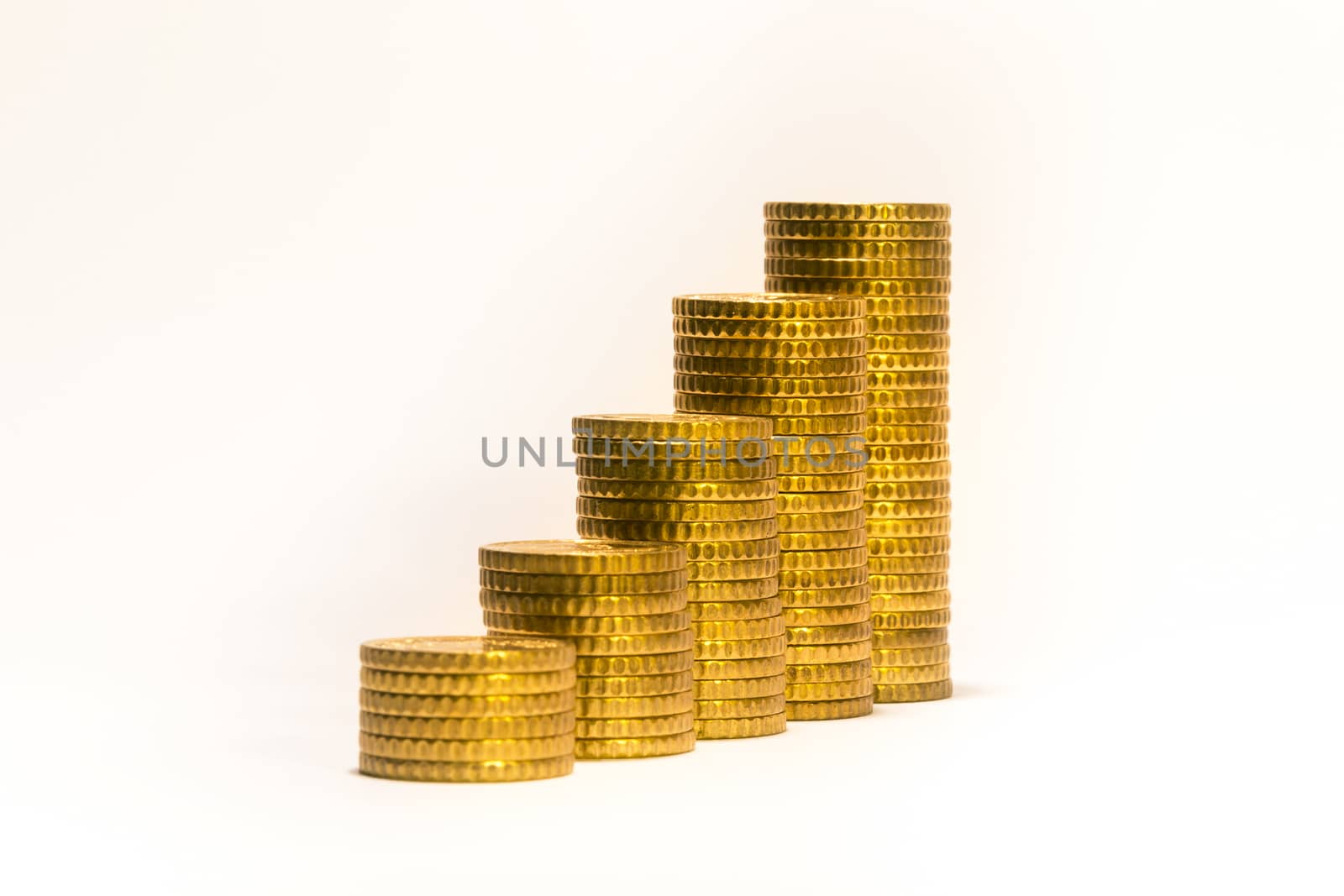Yellow coins lined up from short to tall stacks by enrico.lapponi