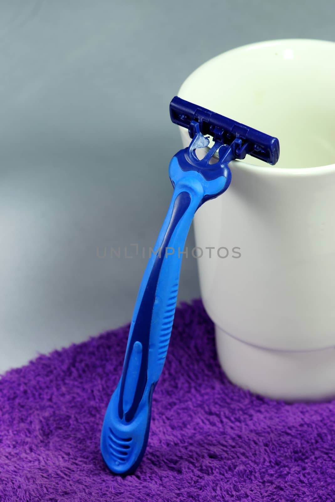 blue razor on purple towel,shallow focus