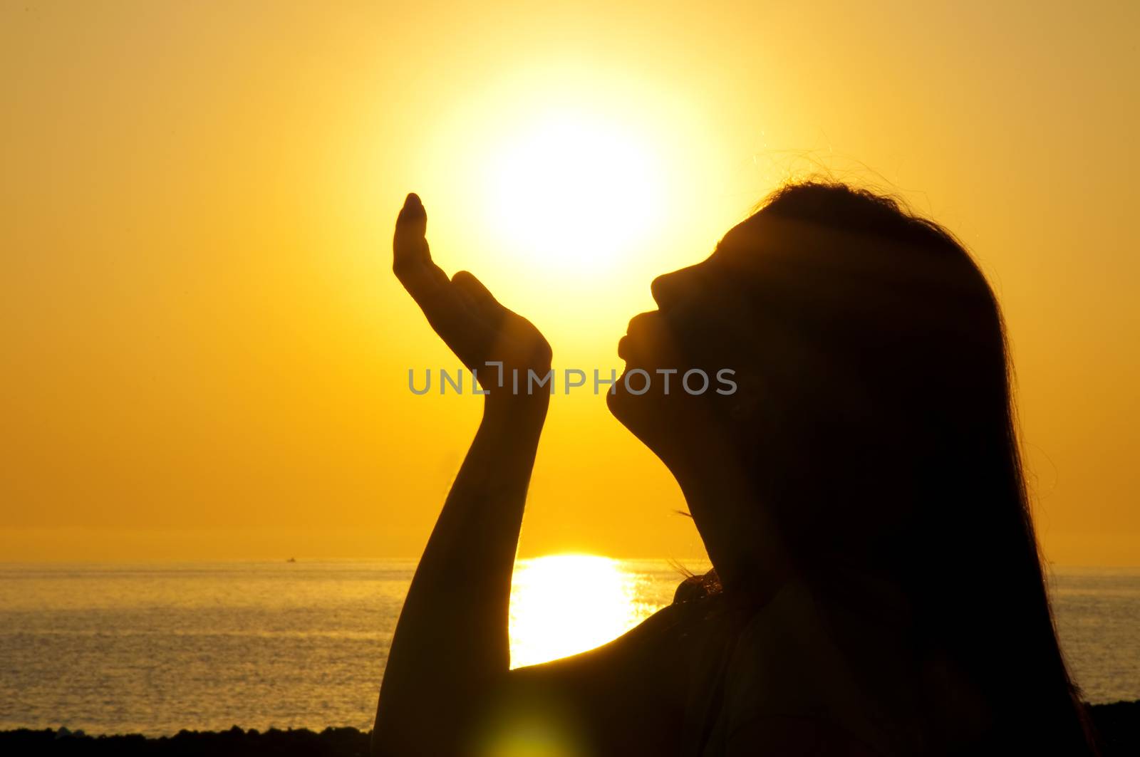 Woman silhouette kiss sun