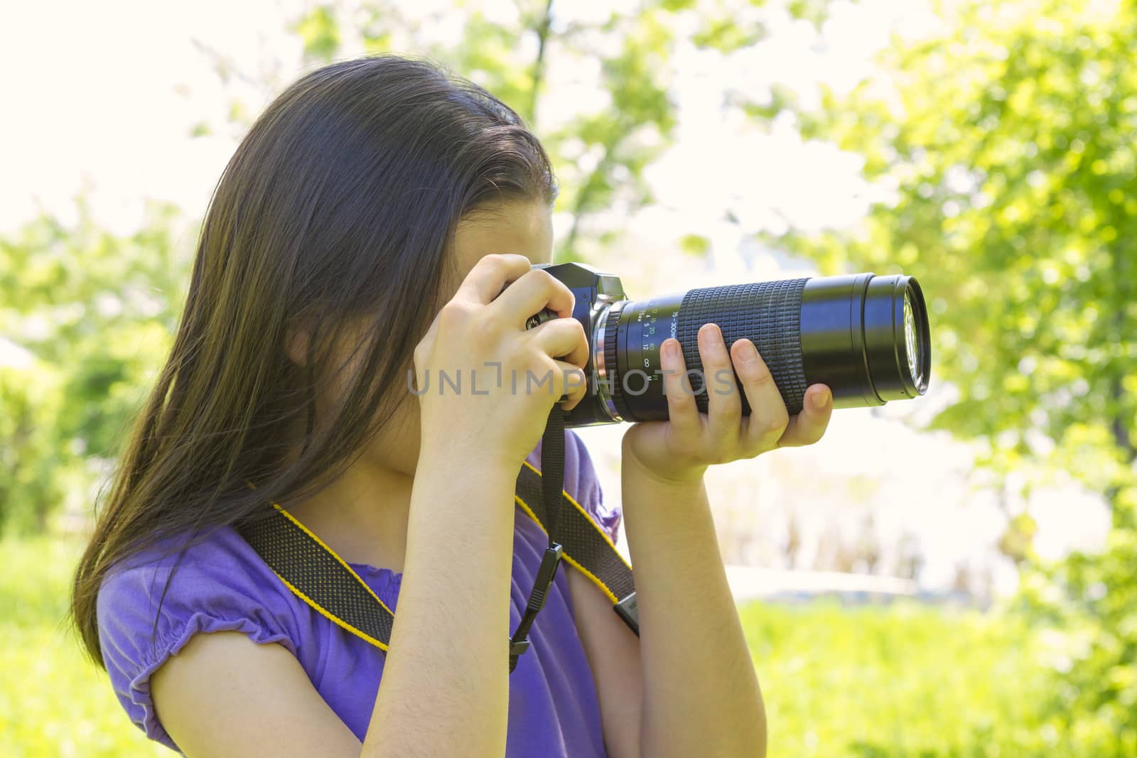 Portrait of brunette girl, taking photos at summer green park.