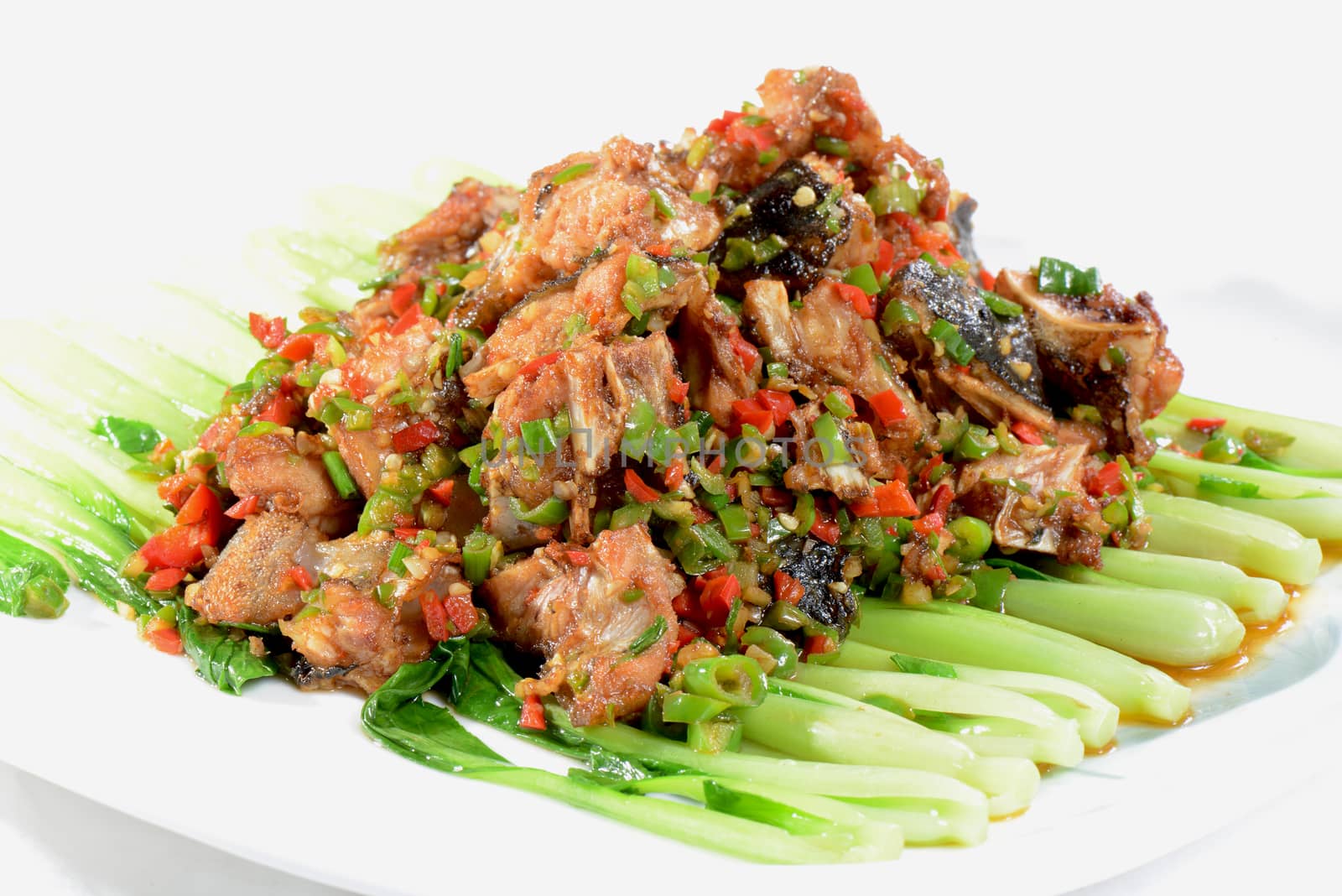 Chinese Food: Fried fish head pieces with green vegetables in a white plate