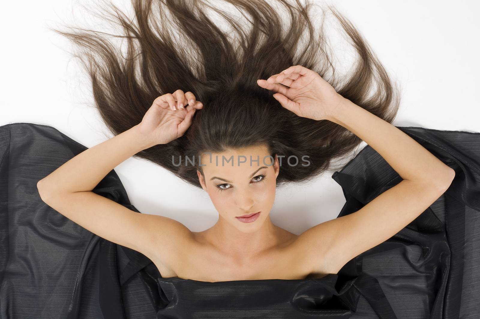 cute and sensual girl laying down with hair on floor and black fabric around