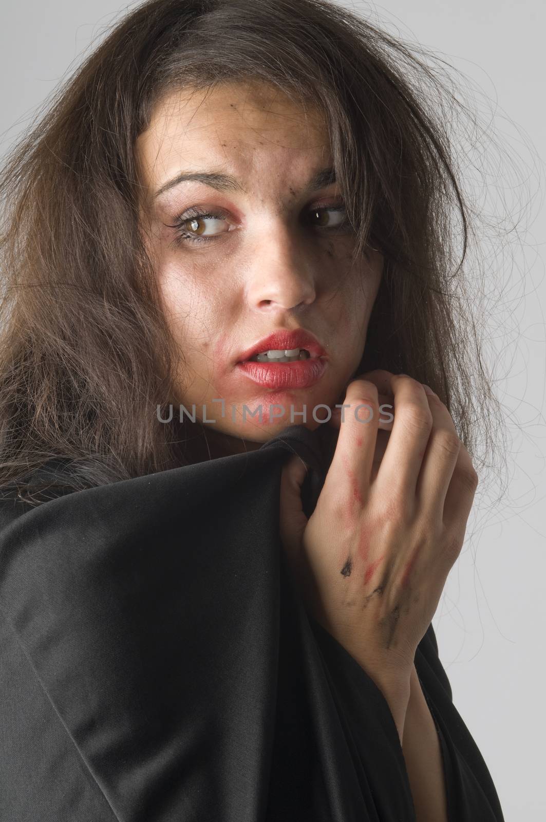 young woman in fear with her make up broken keeping hand close to face