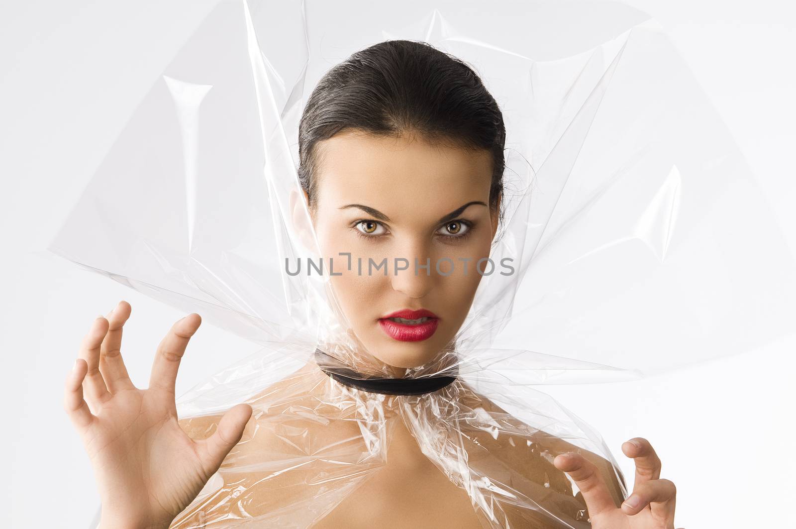 cute girl looking as angry vampire with cellophane as cloak, she looks in to the lens with an aggressive axpression