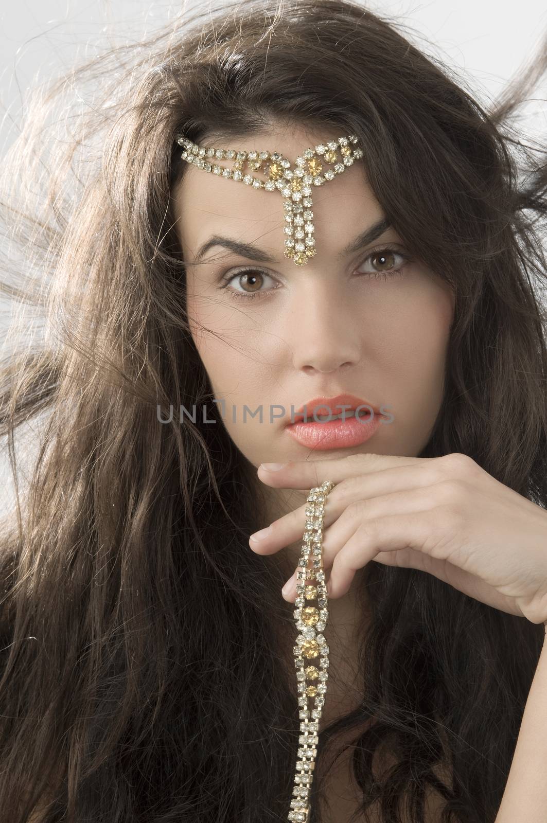 cute brunette with golden jewel and hair in wind