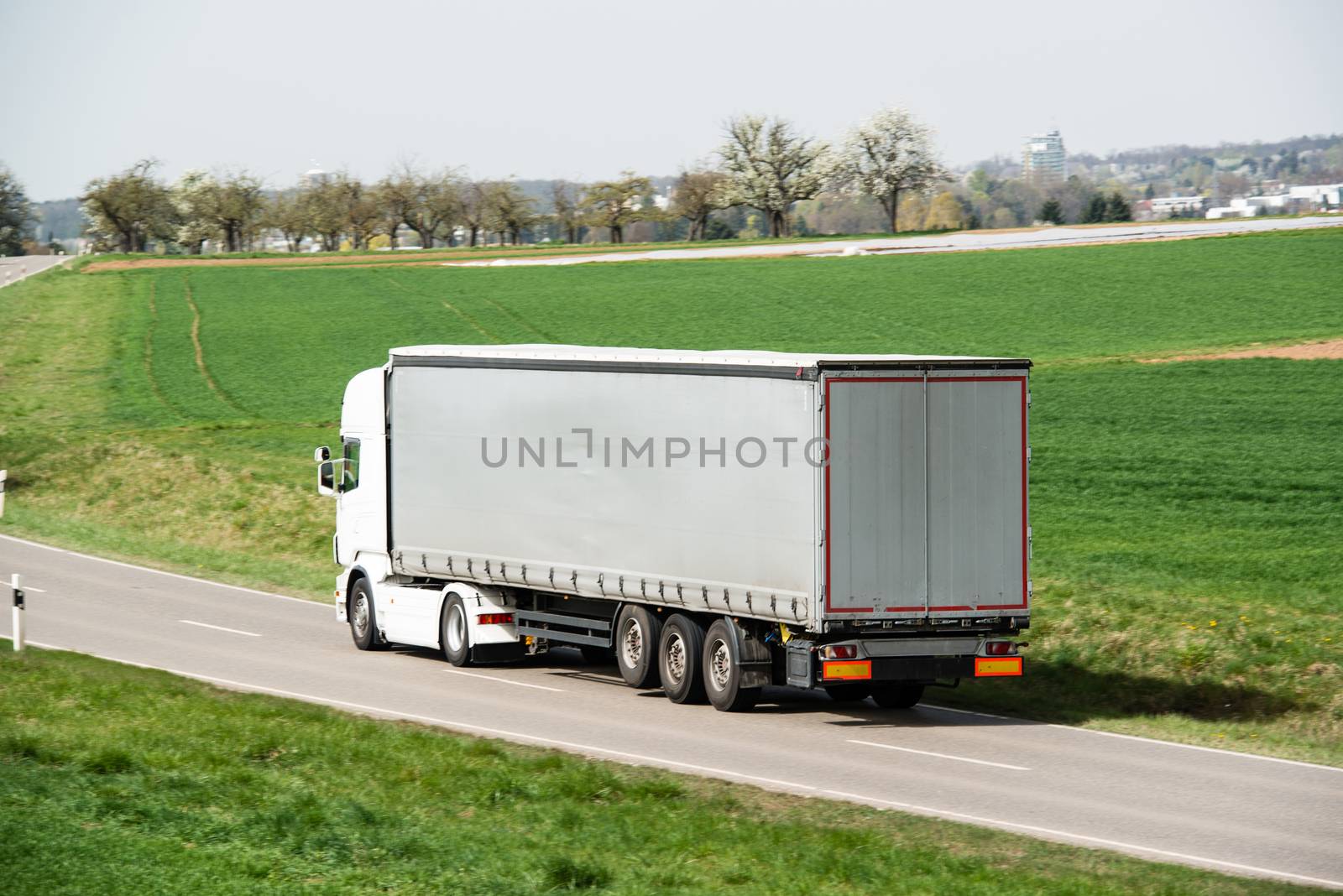 White truck moving on a main road with space for your company logo and text