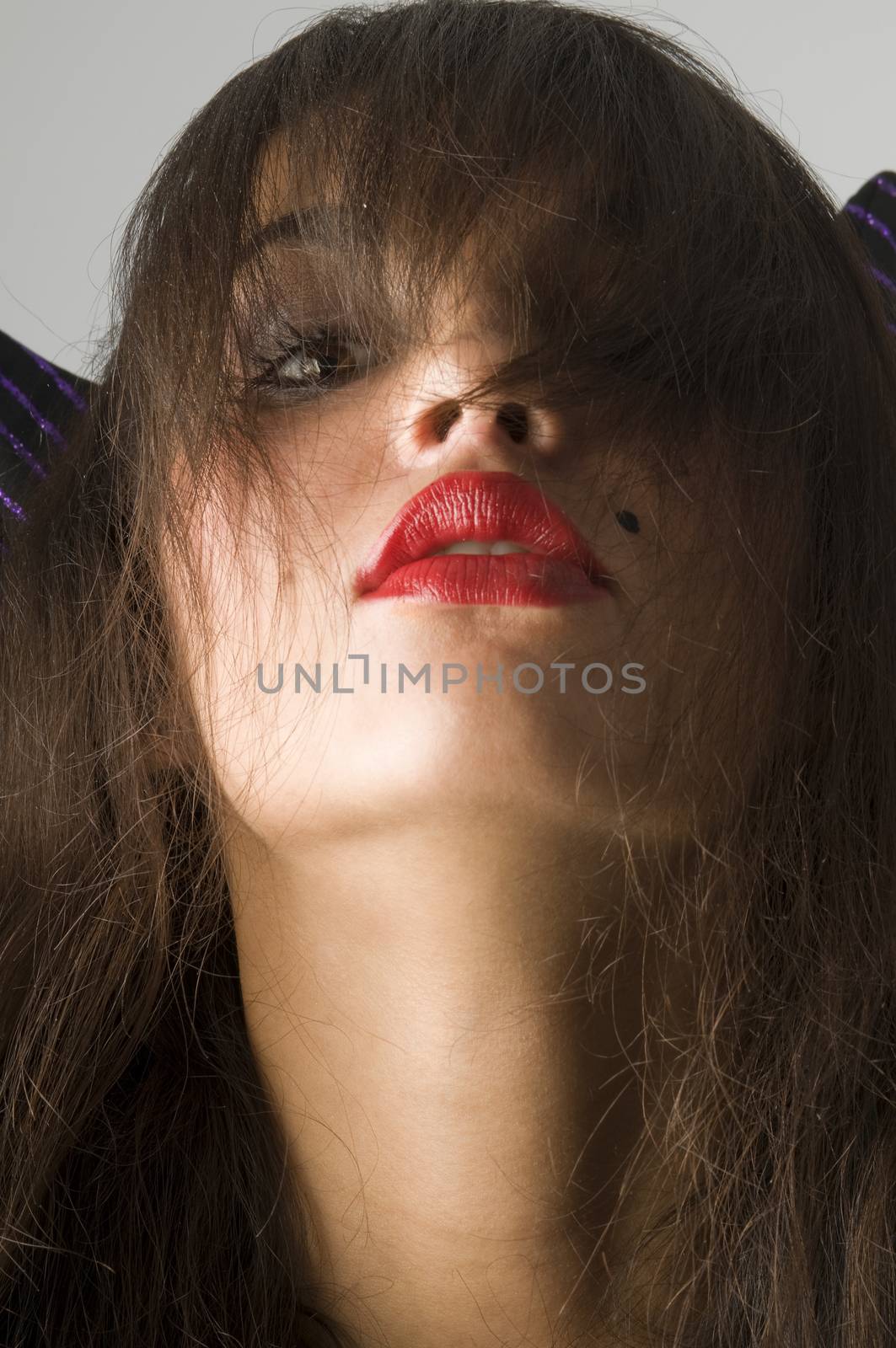 close up of brunette with red lips and long looking like a witch