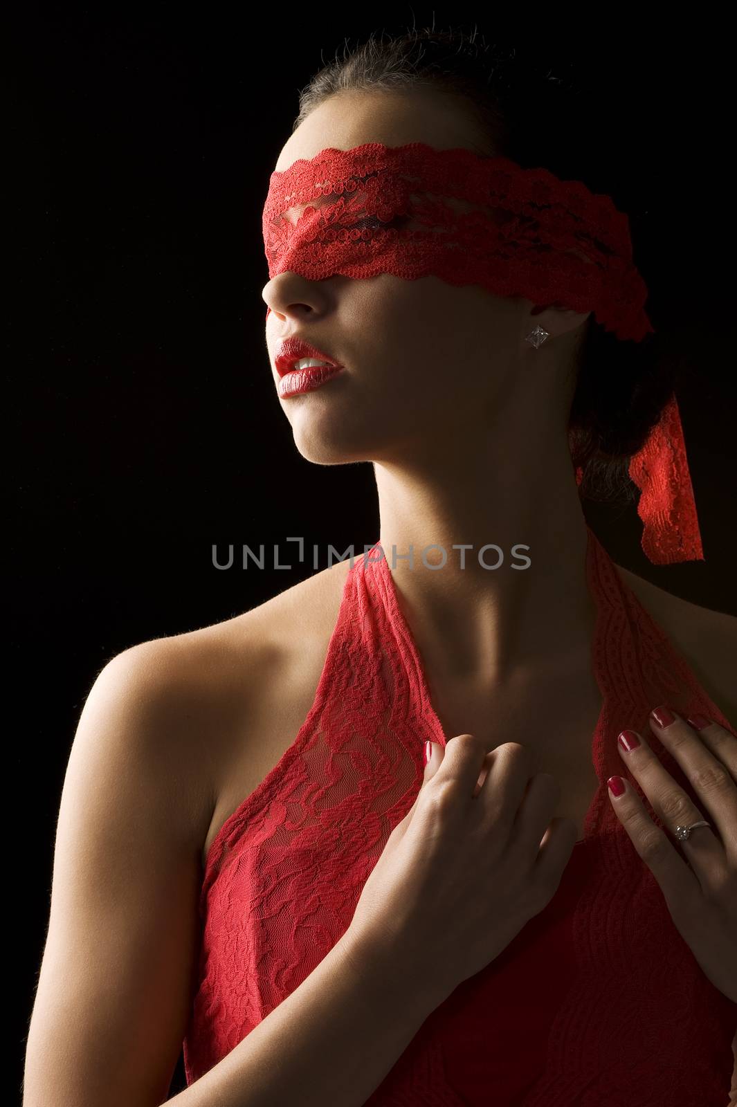 cute brunette portrait on black background with a red mask of lace