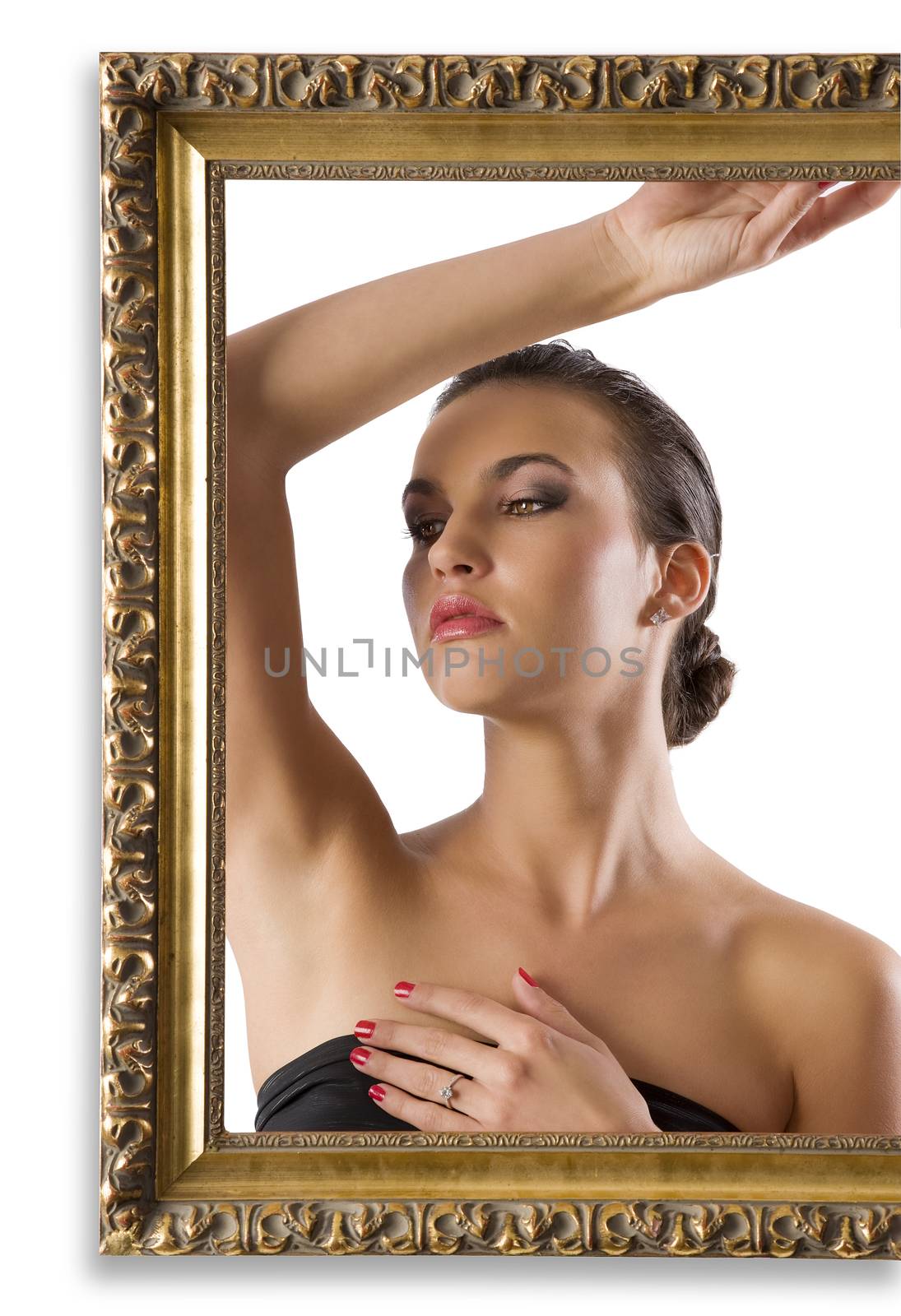 portrait of young and graceful brunette posing behind an old fashion picture frame