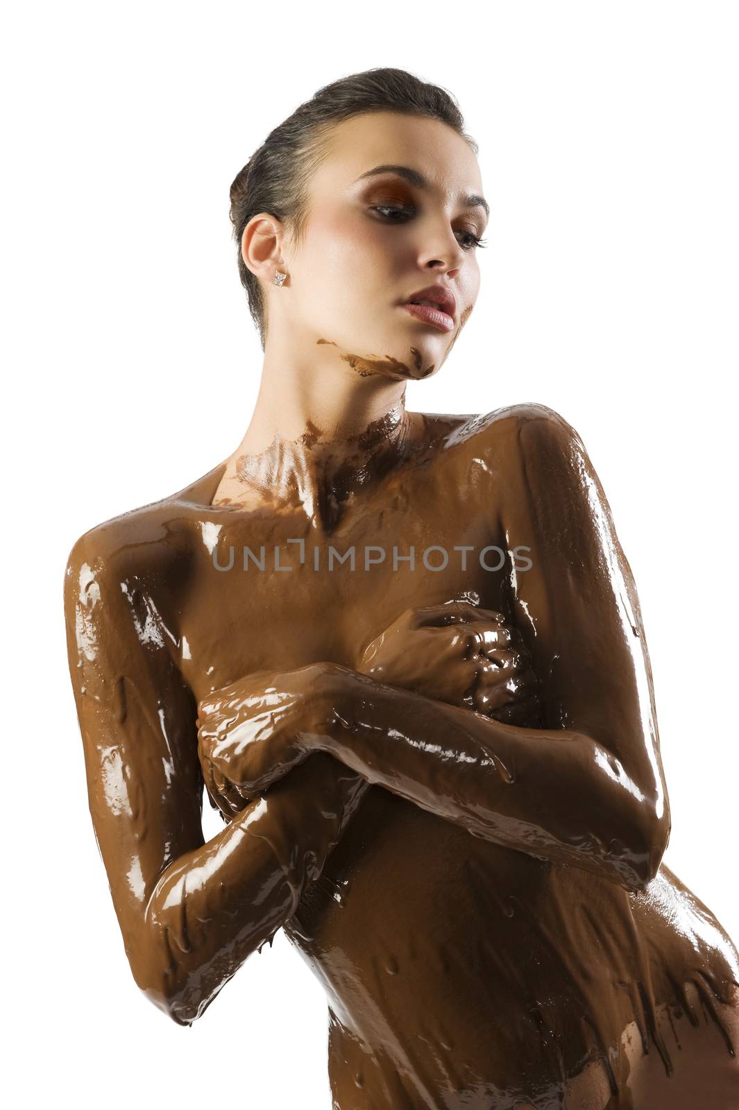 amazing shot of a young beautiful brunette with her naked body covered of sweet cream chocolate