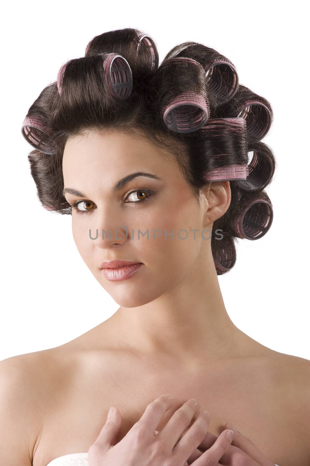 close up portrait of Young beautiful girl having hair curlers on her head isolated on white background