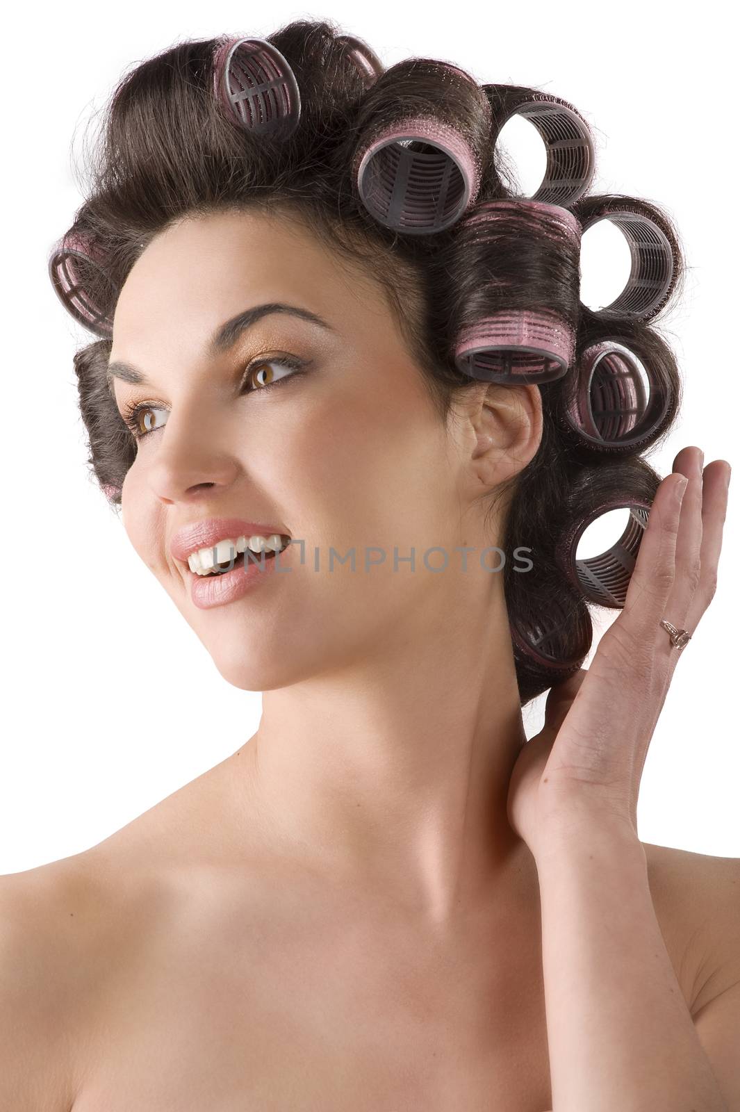 smiling portrait of young beautiful girl having hair curlers on her head isolated on white background