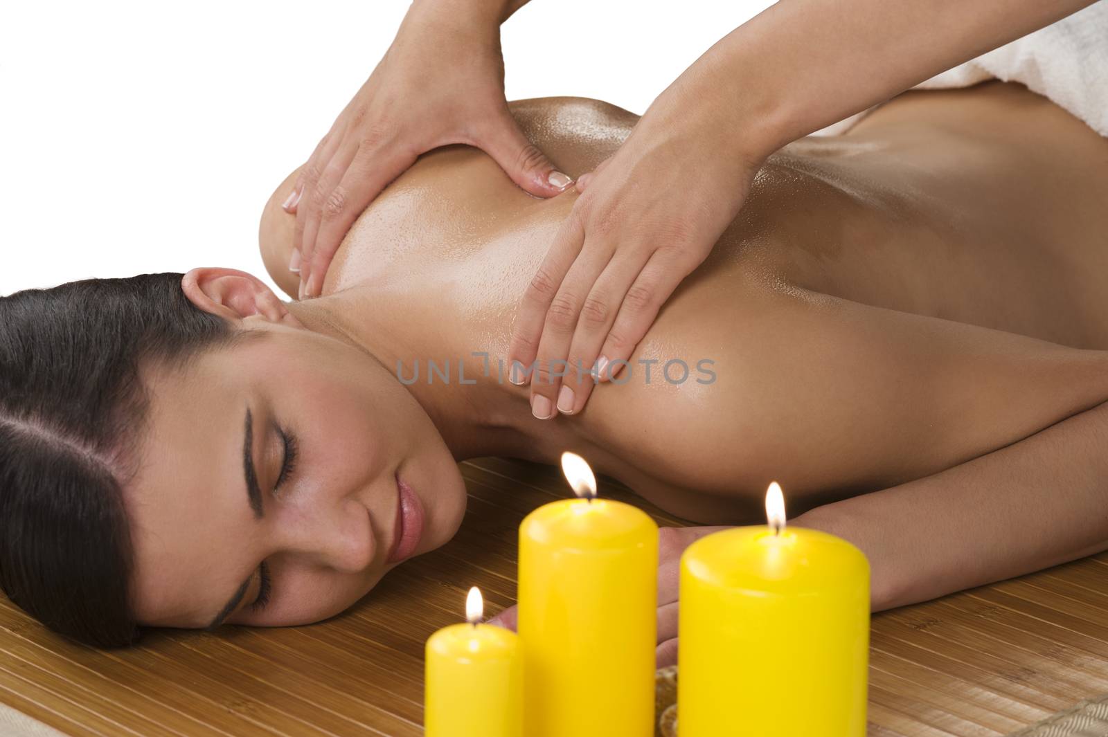 attractive beautiful caucasian woman lying down on a massage bed at a spa with candle