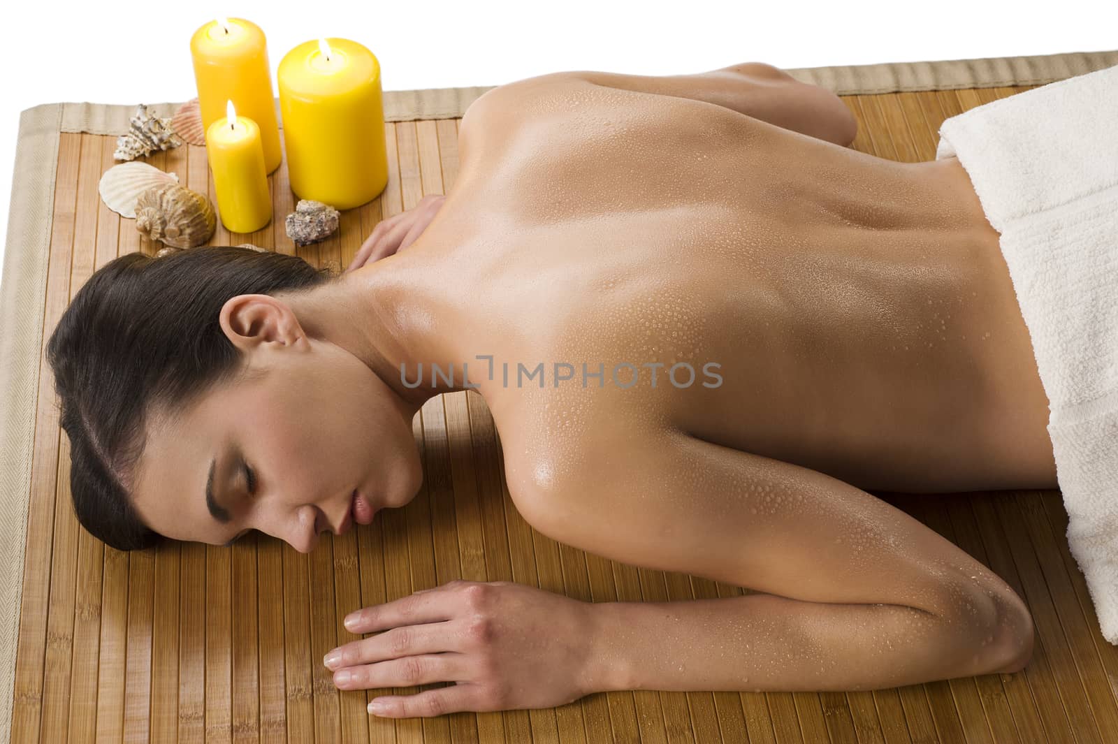 beautiful brunette relaxing herself in a spa with drops of water on her naked shoulder