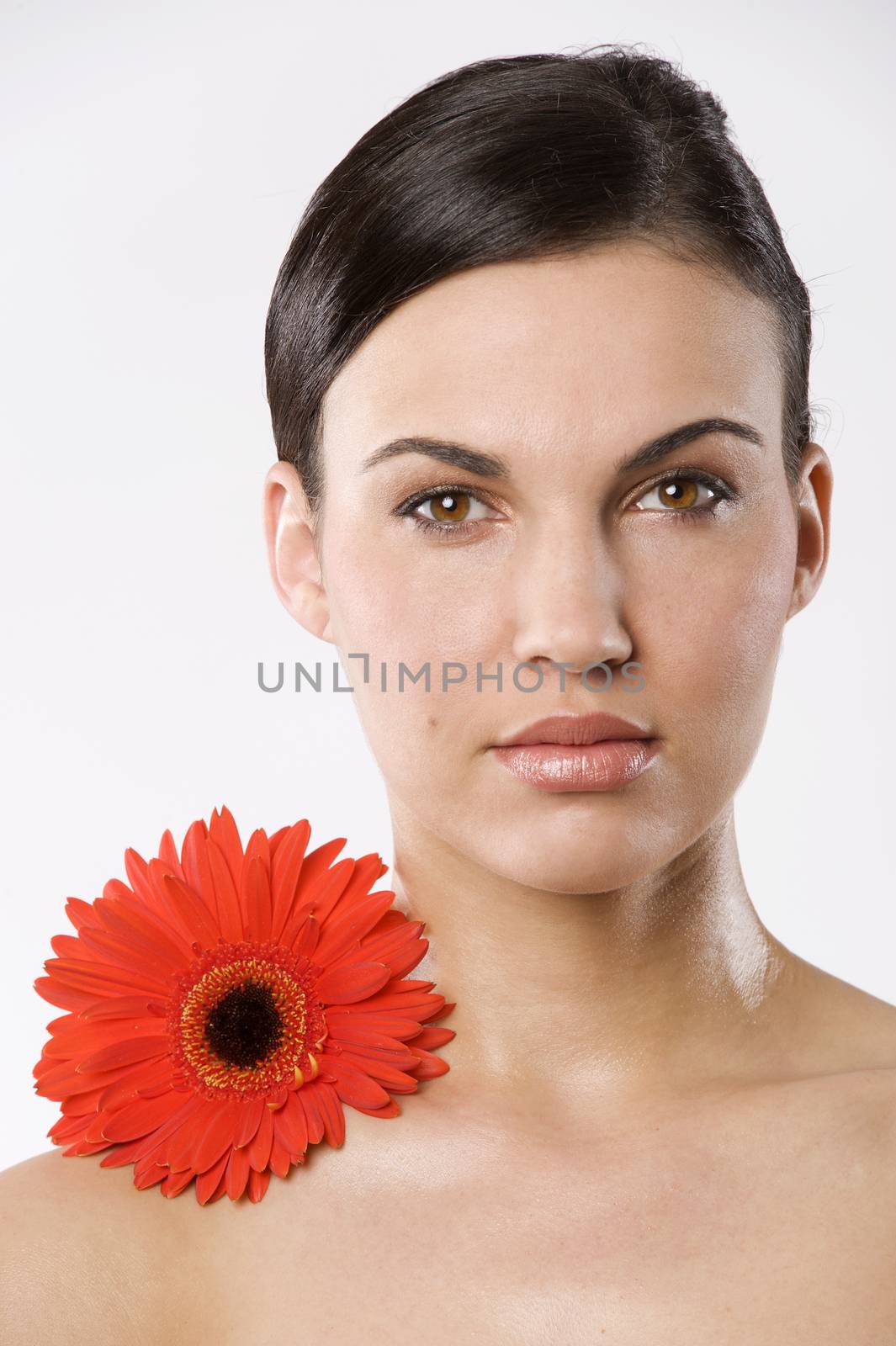 fresh portrait of a young brunette woman wiith color flower without skin retouch