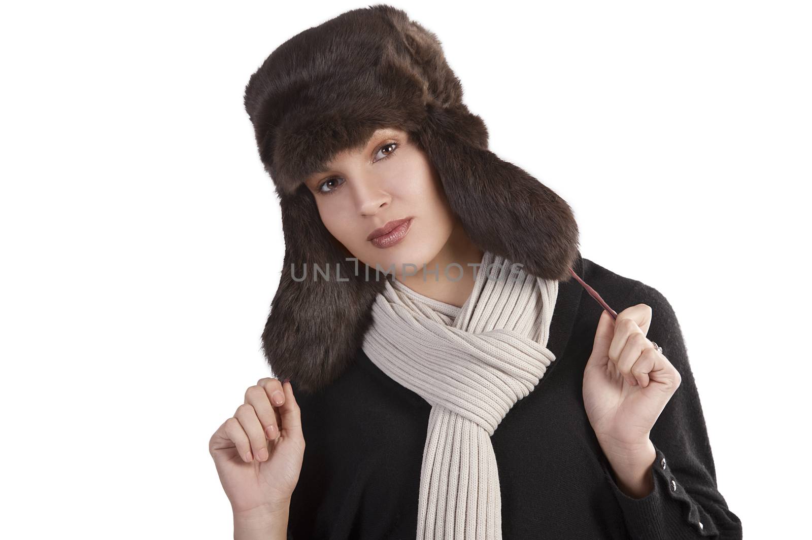 beauty close up portrait of cute female woman with fashion fur hat in winter dress with scarf posing towards the camera against white background