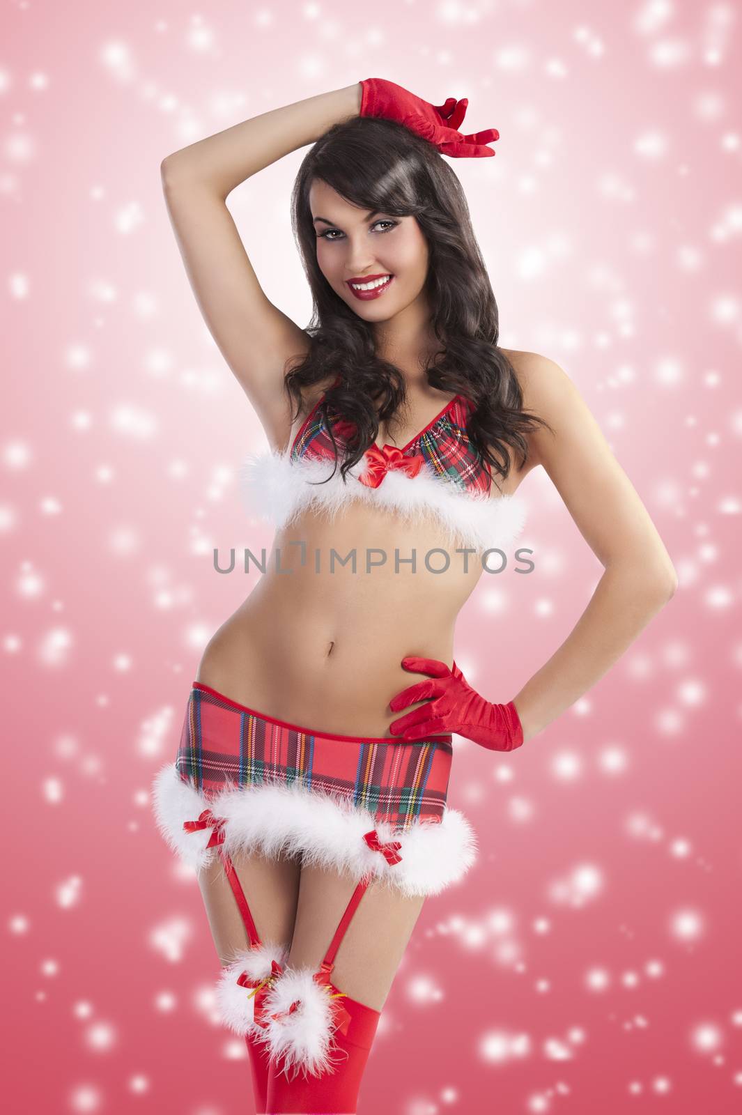 sexy smiling christmas party girl posing in a red christmas baby doll with red stockings and gloves