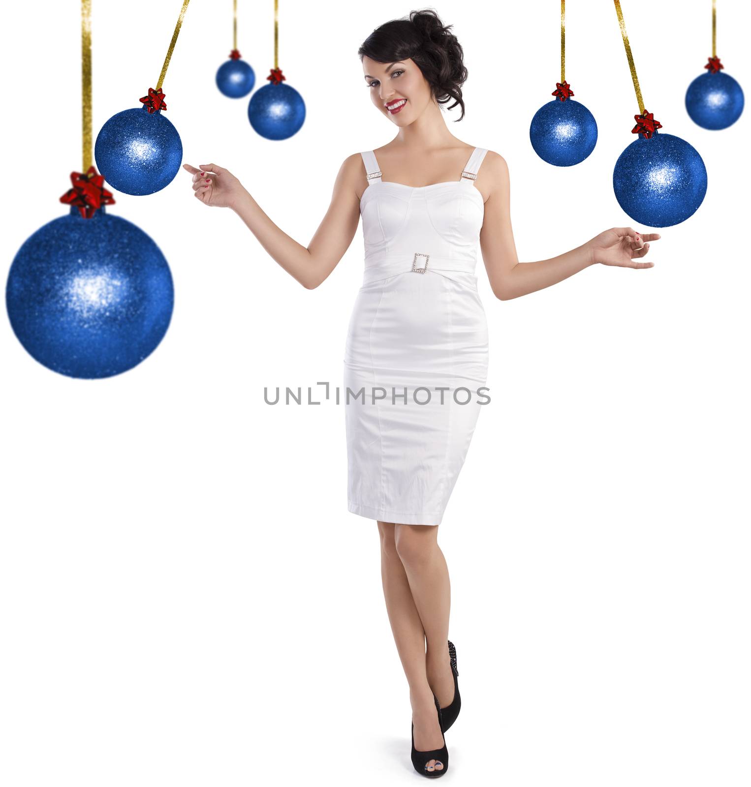 Pretty brunette with hair style and a white dress between christmas ball standing and smiling