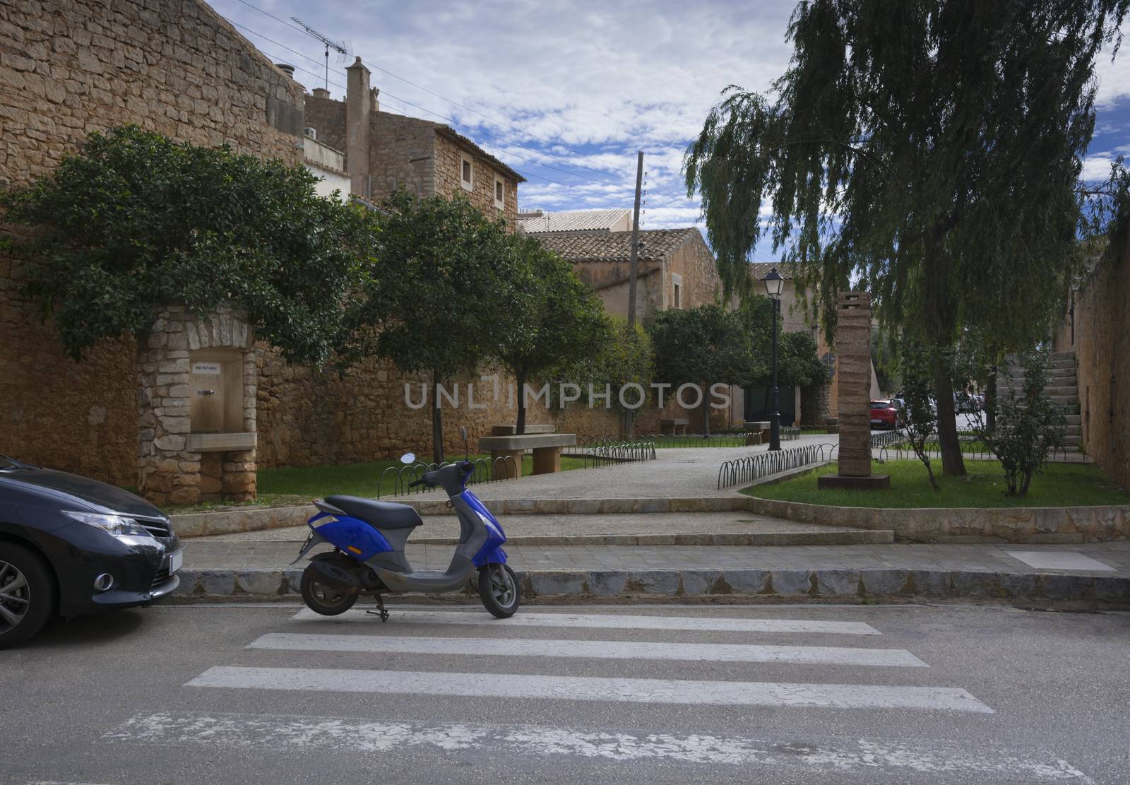 Blue scooter on pedestrian crossing in Mallorca, Balearic islands, Spain.